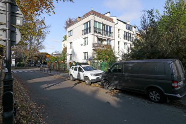 Varşova, Polonya - 1 Kasım 2023: Praga-Poludnie bölgesinin Saska Kepa bölgesinde güneşli bir sonbahar gününde konut binası, sokak ve ağaçlar.