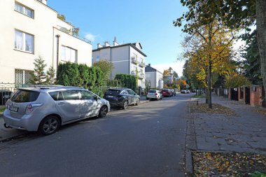 Varşova, Polonya - 1 Kasım 2023: Trafiğin olmadığı cadde boyunca evler, fakat arabalar park halinde, Praga-Poludnie bölgesindeki Saska Kepa konutlarında.