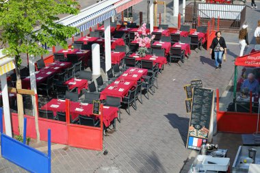 Nice, Fransa - 21 Nisan 2023: Cours Saleya 'daki açık hava restoranı misafirleri ağırlamaya hazır. Masalar zaten kırmızı masa örtüleriyle kaplı, ama koltuklar henüz dolu değil..