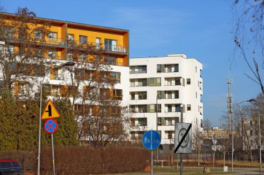 Varşova, Polonya - 30 Ocak 2024: Güneşli bir kış gününde Praga-Poludnie 'nin bir alt bölgesi olan Goclaw' daki konut binaları ağaçların arkasında görülebilir..