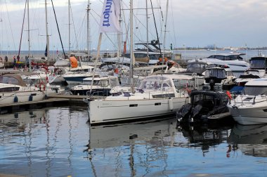 Sopot, Polonya - 6 Ekim 2024: Baltık Denizi 'nin en uzun tahta iskelesinin sonundaki yat limanında demirli yelkenliler. Gökyüzü burada bulutlu.