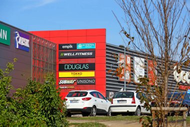 Varşova, Polonya - 24 Ekim 2024: Büyük çok markalı alışveriş merkezinin ön cephesinde çeşitli markalar sergilenmektedir