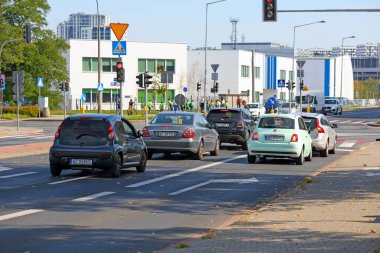 Varşova, Polonya - 24 Eylül 2024: kavşakta trafik sıkışıklığı. Trafik kırmızı bir trafik ışığı tarafından durduruldu. Bir okulun beyaz binası da görülebilir durumda. Goclaw konutlarındaki sokaklar.