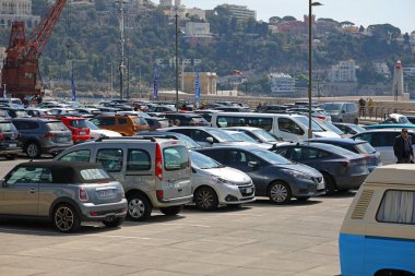 Güzel, Fransa - 23 Nisan 2023: limanın yanında büyük bir otopark ve bir sürü araba var. Tepenin biraz yukarısında bir apartman var.