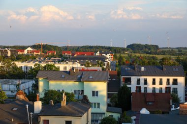 Ustronie Morskie, Polonya - 22 Mayıs 2024: Bu turist kasabasının konut binalarının havadan görünüşü. Ayrıca yakındaki kırsal bölgeleri ve elektrik üreten rüzgar türbinlerini de görebilirsiniz..