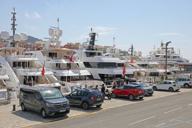 Güzel, Fransa - 23 Nisan 2023 Lymia Limanı, yatlar iskelede demirli. Bu yatları kıç tarafından görüyoruz. Yolun kenarında park etmiş arabalar var..