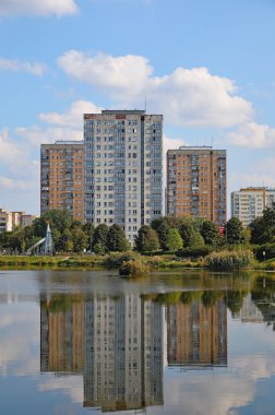 Varşova, Polonya - 21 Eylül 2024: Bir göl arkasında bir grup apartman dairesi görülebilir. Goclaw malikanesinde güneşli bir gün, Praga-Poludnie 'nin bir alt bölgesi..