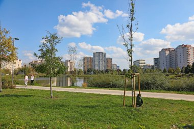 Varşova, Polonya - 21 Eylül 2024: Bir göl arkasında bir apartman bloğu görülebilir. Güneşli bir günde Goclaw malikanesinde, Praga-Poludnie 'nin alt bölgesinde gölü olan bir park da görebilirsiniz..