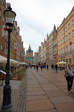 Gdansk, Polonya - 10 Ekim 2024: Dluga Caddesi 'nin her iki tarafında tarihi evler. Bu ünlü gezinti güvertesinin sonunda, Şehir Kapısı 'nı görebilirsiniz..