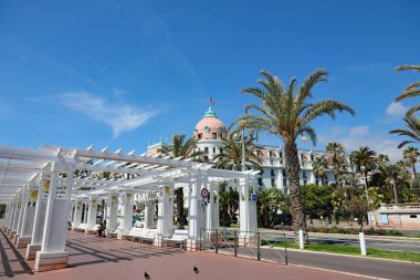 Güzel, Fransa - 26 Nisan 2023: Açık çatılı beyaz bir çardak, Promenade des Anglais 'in diğer tarafında Negresco Oteli' nin bir parçasını görebilirsiniz..