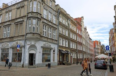 Gdansk, Polonya - 10 Ekim 2024: Evler hala kentin eski kesimindeki kaldırımlı caddelerden biri boyunca ana turizm rotalarından biraz saptı.
