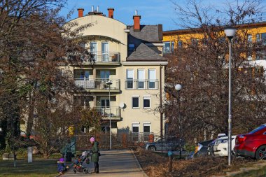 Varşova, Polonya - 30 Ocak 2024: Praga-Poludnie 'nin bir ilçesi olan Goclaw' daki konut binaları, güneşli bir kış gününde ağaçların arkasında görülebilmektedir..