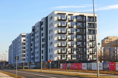 Varşova, Polonya - 30 Ocak 2024: güneşli bir kış gününde görülen beyaz cephe apartmanı. Bu bina Praga-Poludnie bölgesinde büyüyen Goclaw konutlarının bir parçasıdır..