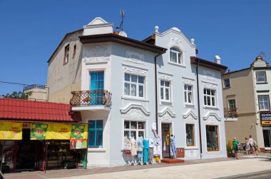 Ustronie Morskie, Polonya - 26 Mayıs 2024: Evin içinde bir giyim mağazası var, ve onun dışında, kaldırımda, satmak için sergilenen malları görebilirsiniz