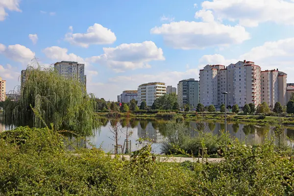 Varşova, Polonya - 21 Eylül 2024: Güneşli bir günde, bir park ve göl kenarındaki bir grup apartman bloğu olan Goclaw 'ın gelişimi.