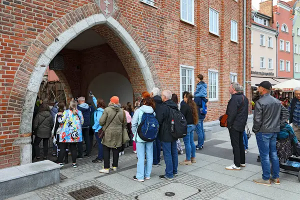 Gdansk, Polonya - 10 Ekim 2024: Birçok insan Chlebnicka Kapısı önünde toplandı. Tüm bu insanlar geçitten tek bir yöne bakıyor. İlginç bir şeyler oluyor olmalı..