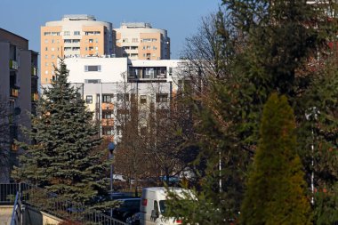 Varşova, Polonya - 10 Şubat 2025: Praga Poludnie bölgesinin bir parçası olan Goclaw konutlarında karsız ve güneşli bir kış mevsiminde ağaçların arkasındaki yerleşim yerleri.