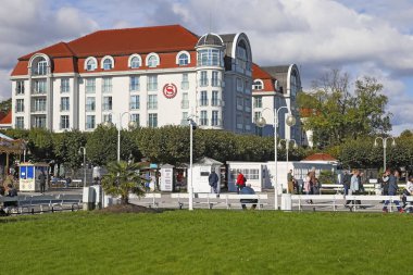 Sopot, Polonya - 6 Ekim 2024: The Sheraton, bu tatil beldesindeki en iyi otellerden biri. Gezinti güvertesinde dolaşan insanlar da var..