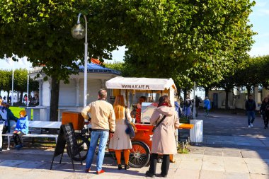 Sopot, Polonya - 6 Ekim 2024: Kaldırımda küçük bir kafe kuruldu. Bu tip küçük, üç tekerlekli kahve dükkanları kahve servisi için mobil bir mağazadır..