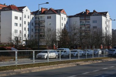 Varşova, Polonya - 10 Şubat 2025 Goclaw konutlarının manzarası. Apartman binası, cadde boyunca park yeri ve yapraksız ağaçlar da var..