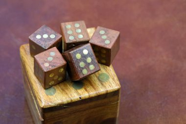 Daha büyük bir zar kutusunun üzerinde beş tane tahta zar var. Bu tema çeşitli finansal, oyun, şans ve risk temaları için kullanılabilir.