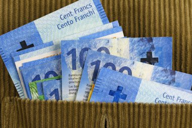 Üzerinde İsviçre frangı olan bir kadife ceket cebi. Bu tema, çeşitli finansal konuları göstermek için kullanılabilir.