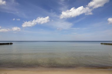 Beyaz bulutlu mavi gökyüzü ve Baltık Denizi 'nin suyu, burada Ustronie Morskie, Polonya' da görüldüğü gibi..