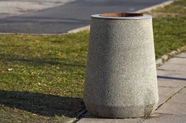 Polonya 'nın Varşova kentindeki Goclaw konut bölgesinde, caddenin yakınındaki kaldırımda çimlerin yanına beton bir çöp kutusu yerleştirildi..