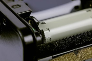 35 mm 'lik eski bir SLR film kamerasının arkası. Film bölümünün kapağı açık. Film hem film rehberinde hem de çekilen makarada..