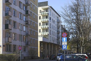 Varşova, Polonya - 28 Mart 2025: Binaların cepheleri kısmen güneşte, kısmen de gölgede. Burada eski ve yeni bir apartman bloğu var. İkisi de dar bir sokakta..