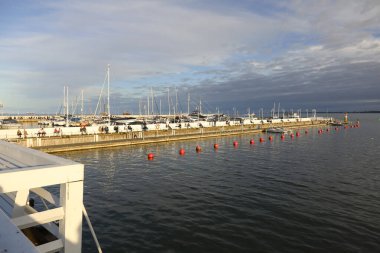 Sopot, Polonya - 5 Ekim 2024: İskelenin ahşap bir parçası, uzakta marina var..