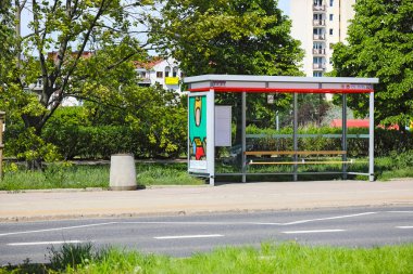 Varşova, Polonya - 2 Mayıs 2025 Goclaw konutlarında kaldırımın kenarında bir otobüs durağı var. Uzakta birçok bitki örtüsü ve apartman bloğu görülebilir..