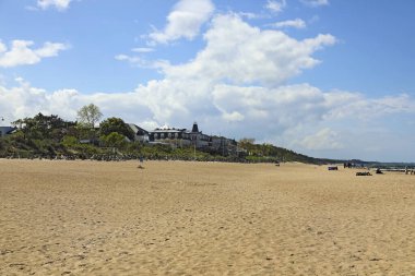 Mielno, Polonya - 24 Mayıs 2025 Baltık Denizi 'nin geniş ve kumlu sahillerinin ardında doğayla çevrili şehir binalarını görebilirsiniz..