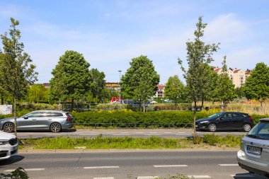 Varşova, Polonya - 2 Mayıs 2025: Caddenin diğer tarafında bir bitki örtüsü bolluğu var. Goclaw bölgesindeki halk parkında çeşitli ağaçlar, çalılar, çiçekler ve bir göl var..