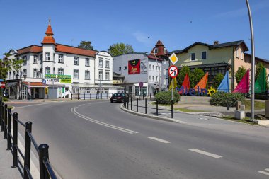 Mielno, Polonya - 21 Mayıs 2025: Yol otelin yanındaki beyaz binayı geçiyor. Bu bina dizaynında küçük bir kuleye sahiptir..