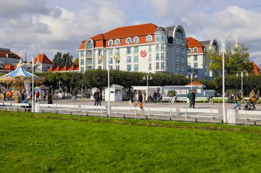 Sopot, Polonya - 6 Ekim 2024: The Sheraton, bu tatil beldesindeki en iyi otellerden biri. Gezinti güvertesinde dolaşan insanlar da var..