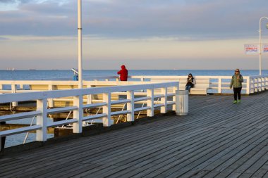 Sopot, Polonya - 7 Ekim 2024: Baltık Körfezi kıyısındaki büyük bir rıhtımın beyaz boyalı bariyerleri ve bankları. Artık orada çok az ziyaretçi var..