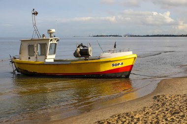 Sopot, Polonya - 9 Ekim 2024: Bir balıkçı teknesi kumlu bir plajın kenarına çekildi. Burada sadece bir tekne var..