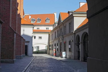 Varşova, Polonya - 4 Nisan 2025: Dziekania Caddesi boyunca kemer kapılı bir manzara. Sokak, Varşova Başpiskoposluğu Başpiskoposluğu ile Başpiskoposluk Müzesi arasında yer alır..