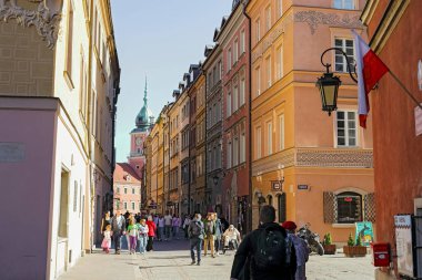 Varşova, Polonya - 4 Nisan 2025: Swietojanska Caddesi manzarası, sonunda Kraliyet Kalesi ve saat kulesi manzarası ile doludur..