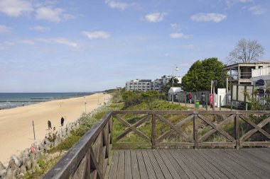 Mielno, Polonya - 13 Mayıs 2025 Baltık Denizi kıyılarının geniş kumlu plajları. Oteller ve apartmanlar da kıyı şeridi boyunca uzanır..