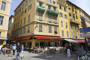 Nice, Fransa - 28 Nisan 2023: Kaldırım restoranları yemek, içki ve güneşli havanın keyfini çıkaran turist ve yerlilerle dolu.