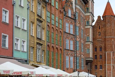 Gdansk, Polonya - 10 Ekim 2024: Şehrin bu bölümü tarihi tuğla mimarisi ile bilinir. Binaların yanında görünen tek şey restoran şemsiyelerinin tepeleri..