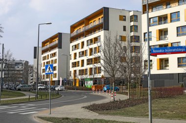 Varşova, Polonya - 12 Mart 2025: Goclaw konutlarının bulunduğu bölgede kaldırımlı bir yol ve apartman blokları bulunan modern bir yerleşim alanı.