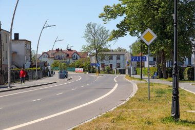 Mielno, Polonya - 20 Mayıs 2025: güzergah şehirden geçiyor. Yolda hiç trafik yok, sadece kaldırımda birkaç kişi var..