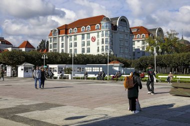 Sopot, Polonya - 6 Ekim 2024: The Sheraton bu tatil beldesindeki en iyi otellerden biridir ve burada gezinti güvertesinden görülebilir. İnsanlar geziniyor..