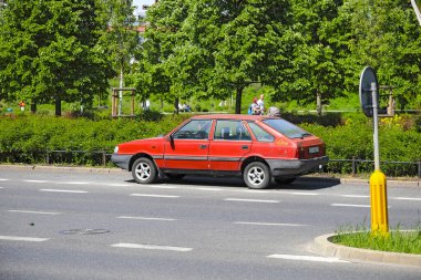 Varşova, Polonya - 2 Mayıs 2025: Eski Polonez arabası, bir zamanlar popülerdi, yol kenarında ağaçların yanında duruyordu. 1978-2002 yılları arasında Varşova Yolcu Otomobili Fabrikası (FSO) tarafından üretilmiştir..