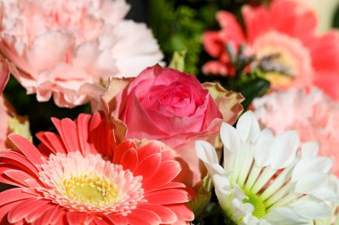 Renkli bir buket yapmak için çeşitli çiçekler kullanan bir çiçek aranjmanı.