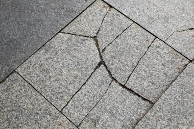 Granit levhalar asfalt bir meydanın yüzeyini oluşturur, bunların bazıları Polonya 'nın Mielno şehrinde çatlaktır.