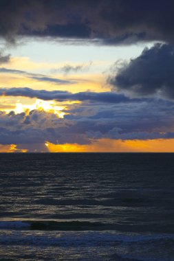 Baltık Denizi 'nin karanlık suları gün batımında renkli bulutların altındadır. Bu fotoğraf, Polonya, Mielno 'dan denize bakarken çekildi..